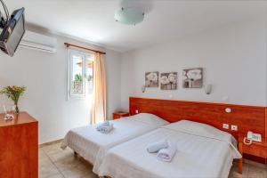 a bedroom with a bed with towels on it at Anemologio 203 Tinos in Agios Ioannis