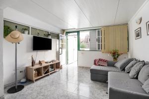 a living room with a couch and a flat screen tv at Apartamento Poris in Arico