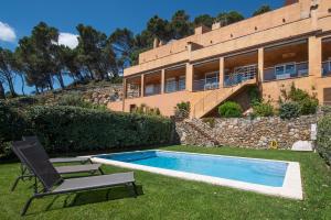 a house with a pool and a chair and a building at Casa Marbello - Begur in Begur