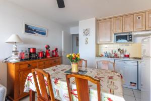 a kitchen with a table and chairs and a kitchen with a stove at Appartement Première ligne plage in Mimizan +10 photos