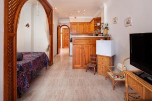 a living room with a bed and a kitchen at Beachfront Bungalow in Torrox Costa