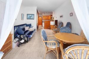 a living room with a couch and a table and chairs at Beachfront Bungalow in Torrox Costa