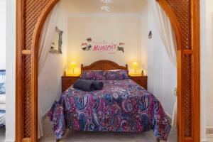 a bedroom with a bed with a wooden head board at Beachfront Bungalow in Torrox Costa +15 photos