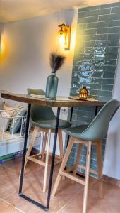 a wooden table with two green chairs and a desk at La Casa Arabe in Alcalá de los Gazules +29 photos