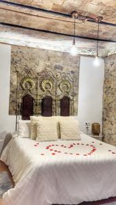 a bedroom with a large bed with red roses on it at La Casa Arabe in Alcalá de los Gazules