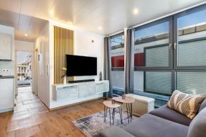 a living room with a couch and a flat screen tv at Hausboot Joana in Zehdenick