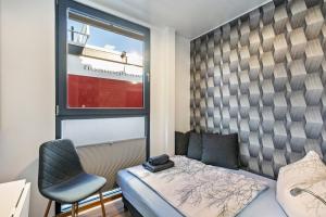 a bedroom with a bed and a chair and a window at Hausboot Joana in Zehdenick
