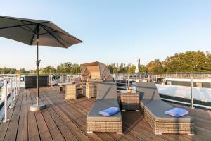 a deck with chairs and an umbrella on a boat at Hausboot Joana in Zehdenick