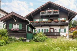 a wooden house with flower boxes on its windows at Ferienwohnung Lengdobler - Burgi in Bad Kohlgrub