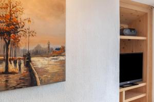 a painting hanging on a wall next to a tv at Ferienwohnung Lengdobler - Burgi in Bad Kohlgrub