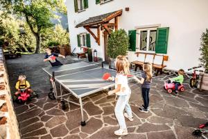 a group of children playing ping pong in a yard at Haus Lohengrin Ferienwohnung 5 in Siusi