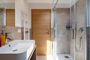 a bathroom with a white sink and a shower at Haus Lohengrin Ferienwohnung 5 in Siusi +22 photos