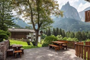 a patio with picnic tables and a view of a mountain at Haus Lohengrin Ferienwohnung 5 in Siusi