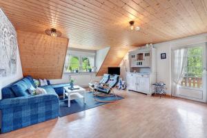 a living room with a blue couch and a wooden ceiling at Ruhbauernhof in Kirchzarten