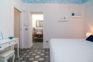 a bedroom with a bed and a desk and a mirror at A Ugghia- I Mori in Fiumefreddo di Sicilia