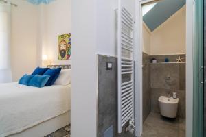 a bedroom with a bed and a bathroom with a sink at A Ugghia- I Mori in Fiumefreddo di Sicilia +19 photos