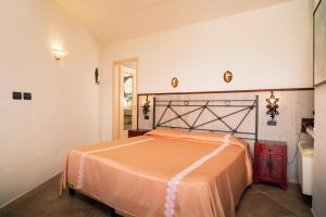 a bedroom with a bed with an orange bedspread at Garden Cottage I Dammusi - Limoni in Castelmola +15 photos