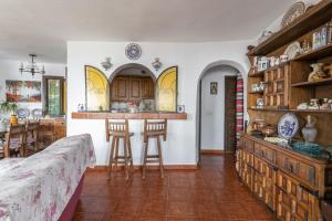 a room with a kitchen and a bar with stools at Villa Paraíso Azul in Salobreña