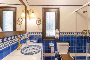 a blue tiled bathroom with a toilet and a sink at Villa Paraíso Azul in Salobreña +31 photos