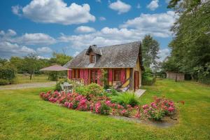 a small house with flowers in the yard at La Cidrerie in Cresseveuille