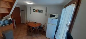 a small kitchen with a table and a microwave at La Cidrerie in Cresseveuille +17 photos