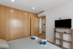 a bedroom with a bed and a flat screen tv at Vale viver in Vale de Cambra