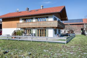 a large house with a deck and a roof at Ferienwohnung Seeblick in Bad Heilbrunn