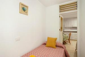 a bedroom with a bed with a yellow pillow on it at Apartamento Danoe 2 in Mogán