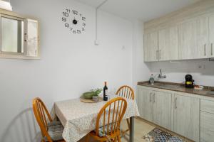 a kitchen with a table and a clock on the wall at Apartamento Danoe 2 in Mogán +12 photos