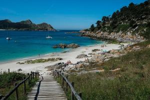a beach with a wooden pathway leading to the ocean at Almar in Vigo