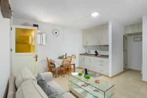 a living room with a white couch and a table at Apartamento Danoe 2 in Mogán
