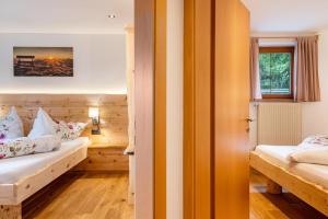 a bedroom with two beds and a window at Wegscheiderhof Apt Gartenwohnung in Velturno