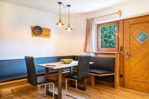 a dining room with a table and chairs at Wegscheiderhof Apt Gartenwohnung in Velturno