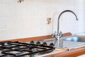 a kitchen counter with a sink and a stove at Appartamenti Cavour codice F in Villasimius