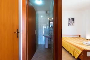 a bedroom with a bed and a shower and a sink at Appartamenti Cavour codice F in Villasimius