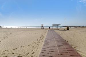 a boardwalk on a beach with a volleyball goal at Apartamento La Burrita in San Agustin