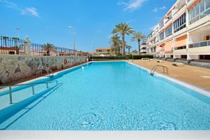 a large swimming pool next to a building at Apartamento La Burrita in San Agustin
