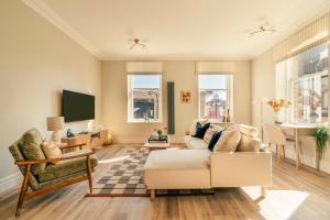 a living room with a couch and a tv at St James Apartments - Harrogate in Harrogate