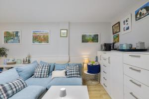 a living room with a blue couch and a kitchen at Host Dalies in Premia de Dalt