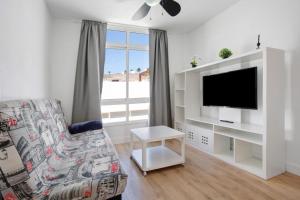a living room with a couch and a tv at Penthouse 3A in Morro del Jable