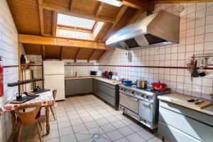 a large kitchen with a stove and a sink at Chalet la savoyarde in Châtel