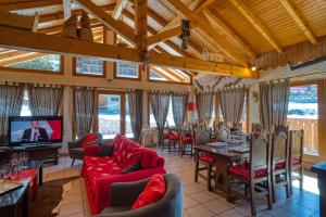 a living room with couches and a television and tables at Chalet la savoyarde in Châtel
