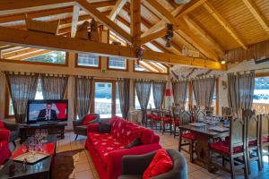 a large living room with red couches and a television at Chalet la savoyarde in Châtel +14 photos