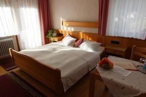 a bedroom with a large bed and two tables at Gästehaus Heimenberg in Bad Rippoldsau-Schapbach