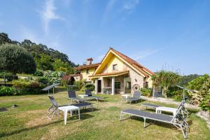 a group of chairs sitting on the grass in front of a house at Casa Nueva de Bueu in Bueu