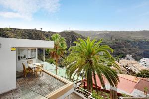 a house with a balcony with a palm tree at Piso Loft tropical Doa in San Marcos