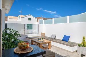a patio with a bench and a bowl of fruit on a table at Casa Mara 2 in Playa Quemada