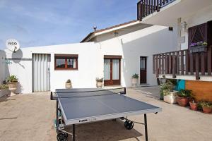 a ping pong table in front of a house at Apartamento Cali com Piscina in Apúlia