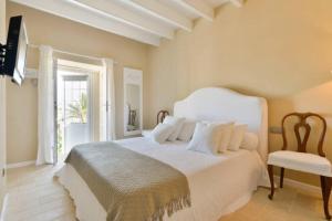 a bedroom with a white bed and a chair at Dalt Vila House in Ibiza Town