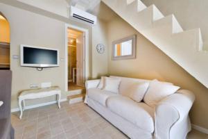 a living room with a white couch and a tv at Dalt Vila House in Ibiza Town +3 photos